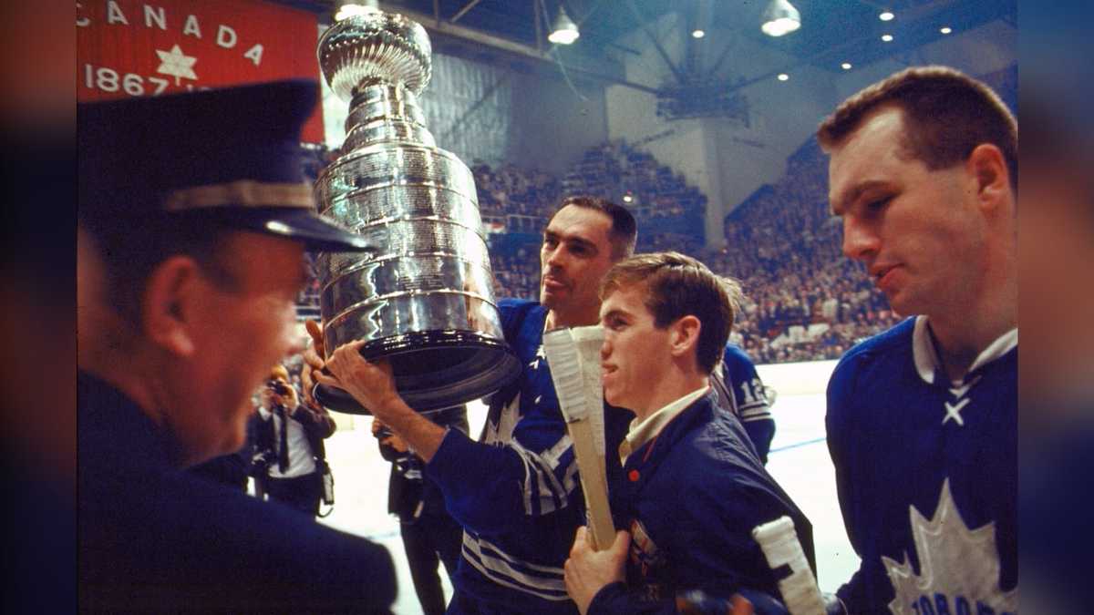 Close-up of the Stanley Cup held by a Maple Leafs player in 1967, engraving visible