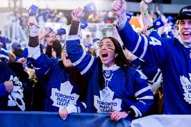 William Nylander celebrating after scoring a goal, arms raised and teammates joining the celebration
