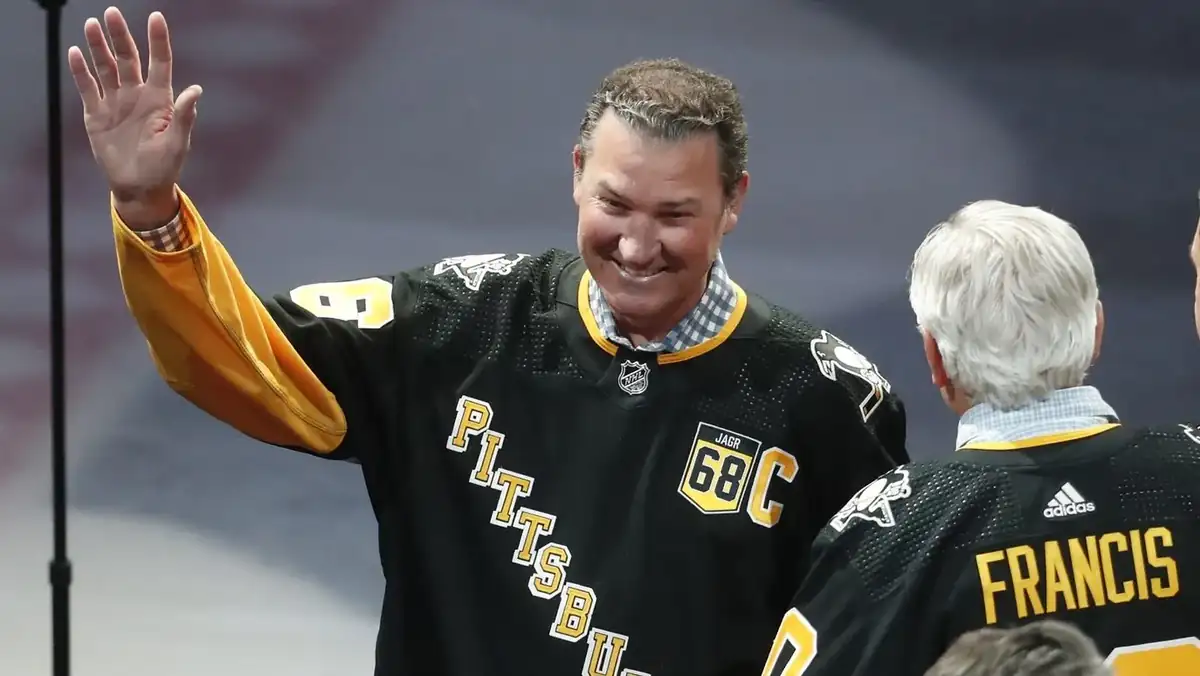 Mario Lemieux celebrating a signature goal with arms raised in front of cheering teammates