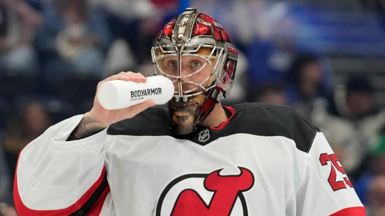 Close-up of the classic New Jersey Devils logo embroidered on a vintage red hockey jersey