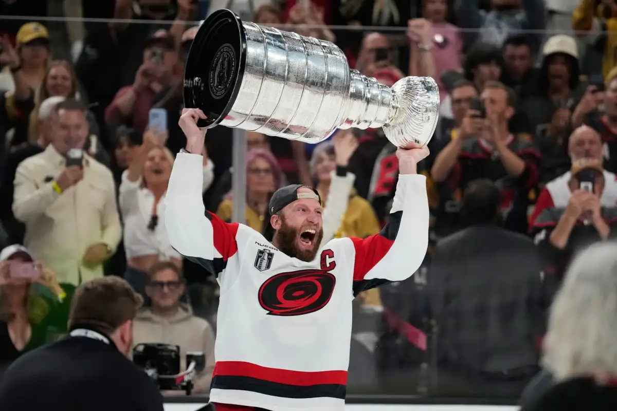 Players hoisting the Stanley Cup on the ice amid a championship celebration