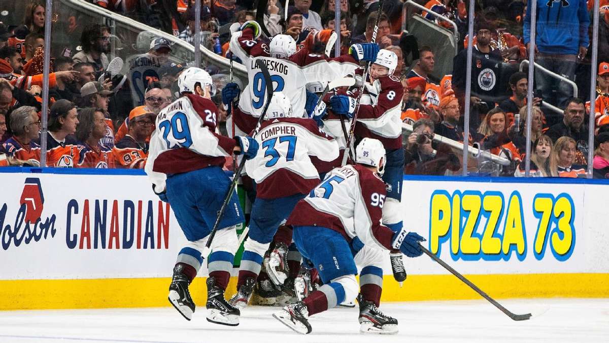 Full arena during a tense playoff game with fans standing and banners waving